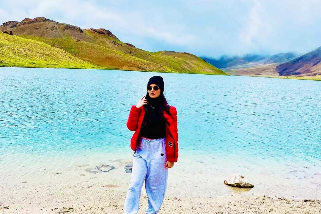 A girl stands in frount of chandratal Lake